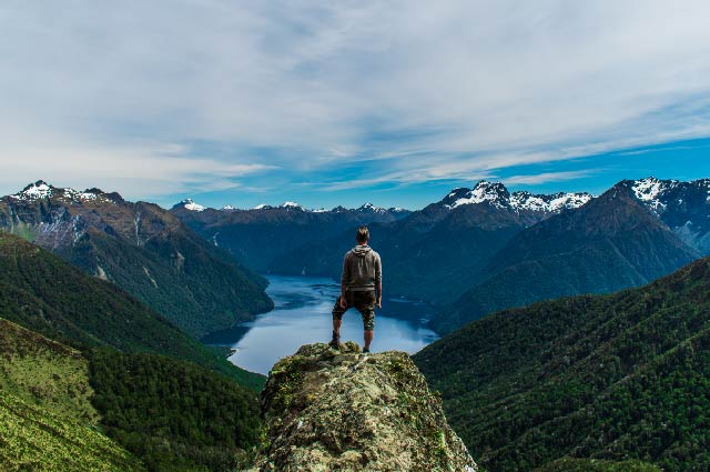 Male standing high on the Kepler Track looking down over a water view