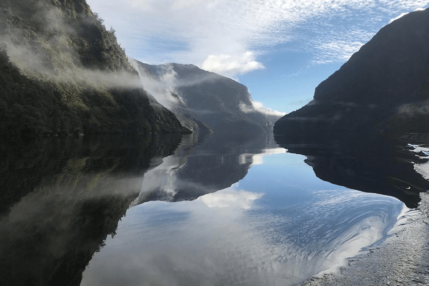 Calm waters of Doubtful Sound showing the reflections of the surrounding mountains