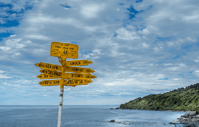 Yellow sign showing distances to major cities from Stirling Point near the small southern town of Bluff
