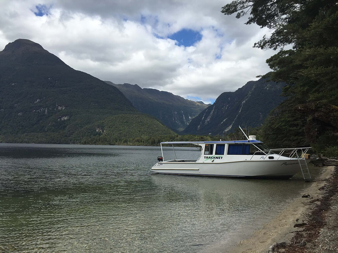 Tracknet vessel, Piopiotahi, pulled up at a beach on Lake Manapouri