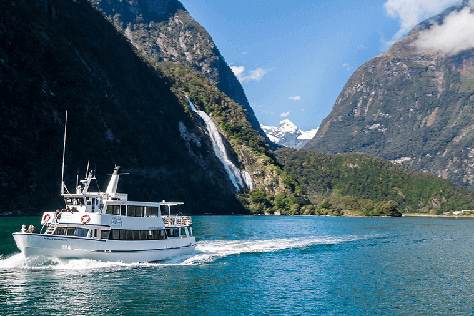 Milford Adventurer vessel on the waters of Milford Sound during a Milford sound cruise with the Lady Bowen falls seen in the background